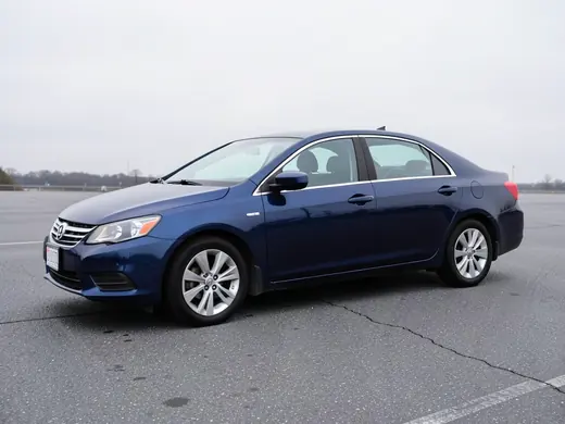 The reference: a photo of a dark blue sedan in a car park
